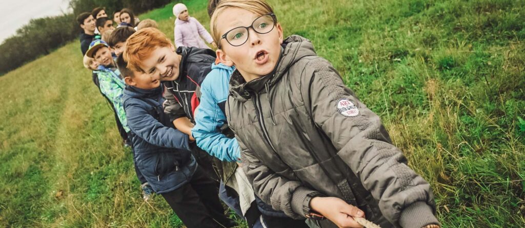 Maatapaamiset tuovat vertaiset yhteen. Kuvassa lapset vetävät köyttä pellolla.